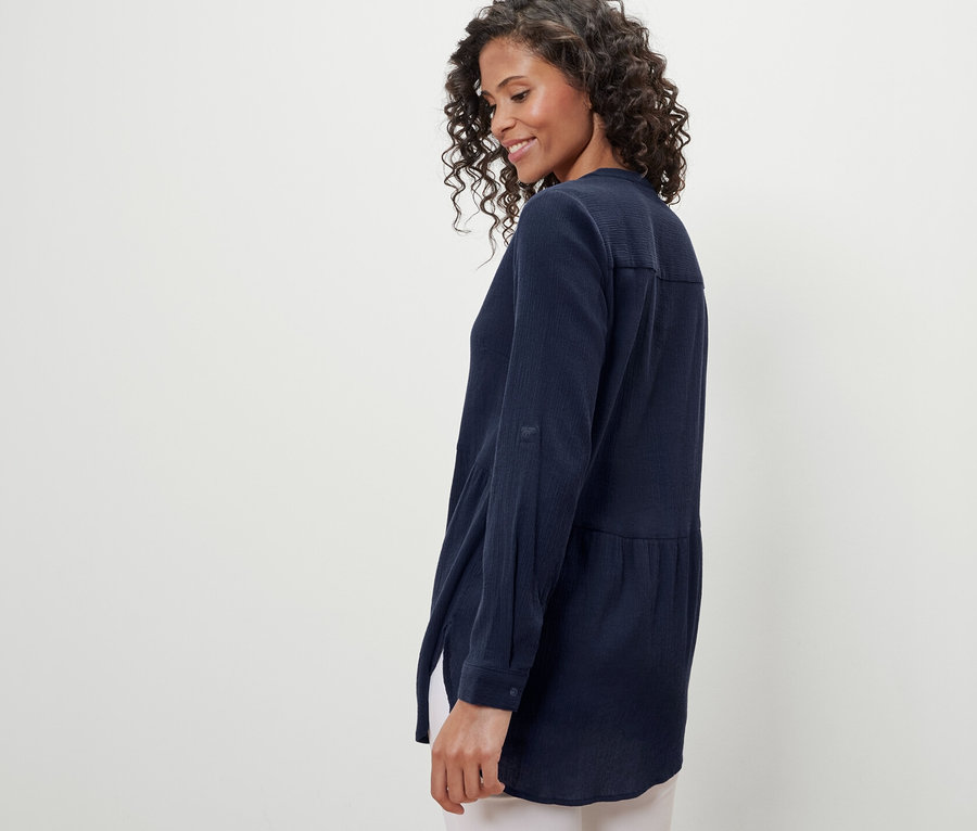 Femme portant une blouse longue bleu marine.