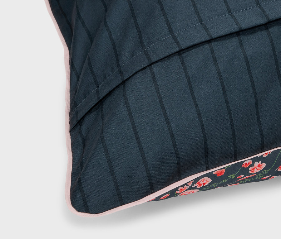 Détail d'une parure de lit en renforcé de taille standard avec des rayures et un motif floral.