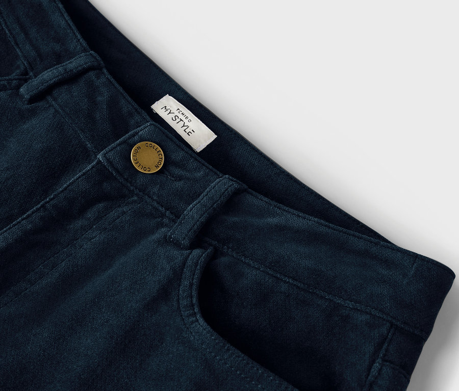 Gros plan d'un pantalon bleu marine avec bouton et poche.