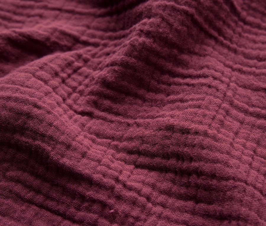 Gros plan sur la texture d'un tissu bordeaux.