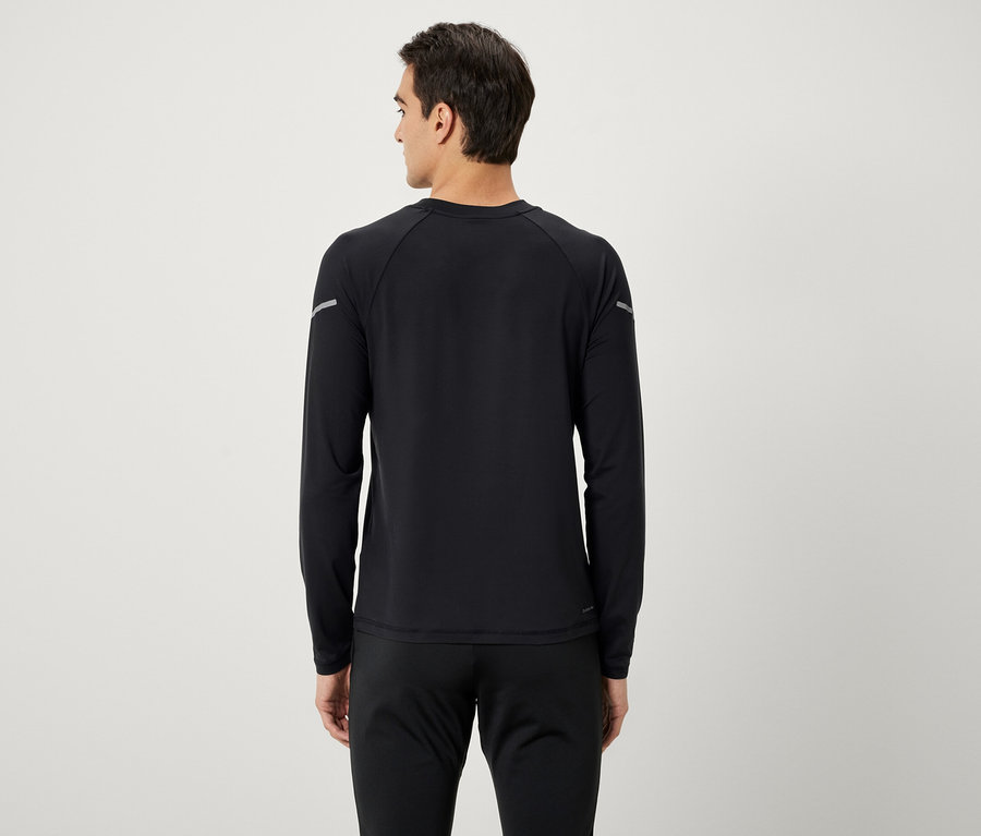 Un homme, vu de dos, porte un t-shirt noir à manches longues et un pantalon de survêtement noir.