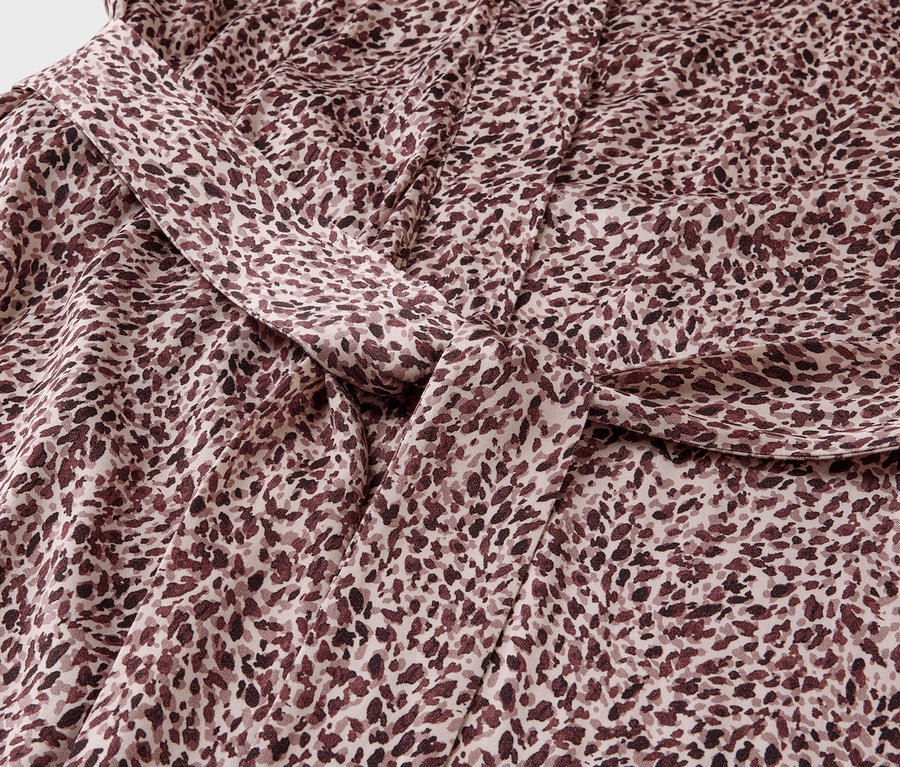 Gros plan d'un tissu avec un motif tacheté marron et un nœud.