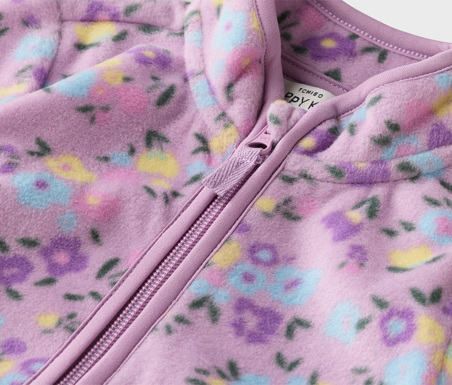 Gros plan d'une veste en polaire violette avec fermeture éclair et motif floral.