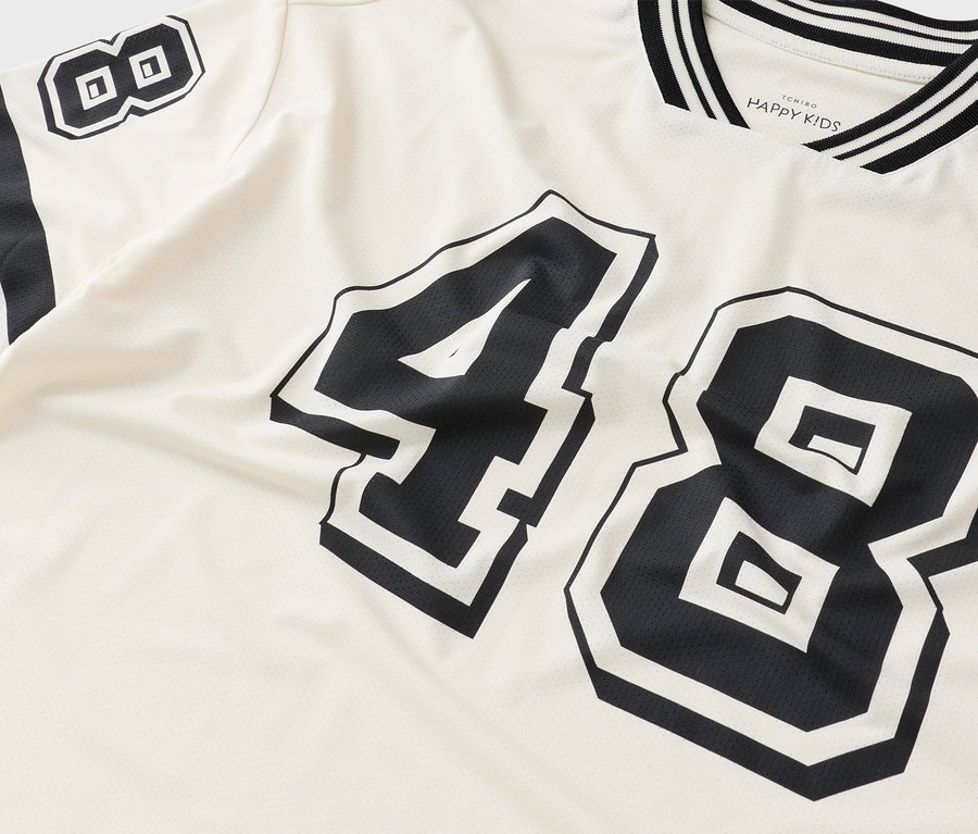 Gros plan d'un t-shirt avec le numéro 48 en noir sur un tissu de couleur crème.