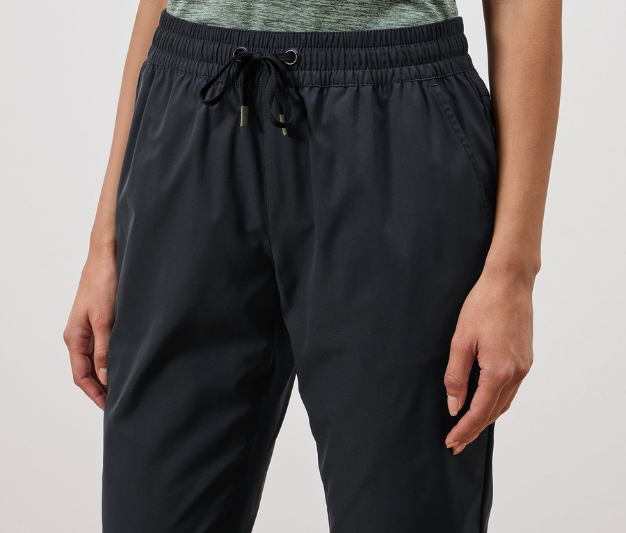 Gros plan d'une femme portant un pantalon de survêtement bleu marine avec cordon de serrage.