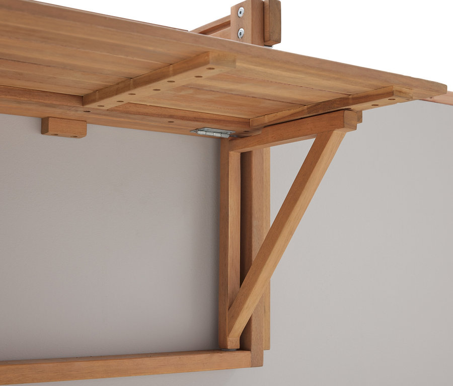 Gros plan d'une table pliante en bois montée sur un mur gris.