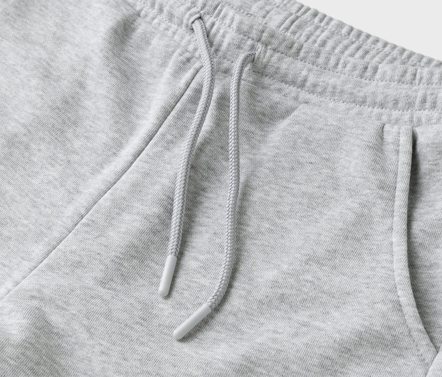 Gros plan d'un pantalon de survêtement gris avec cordon de serrage et poche.