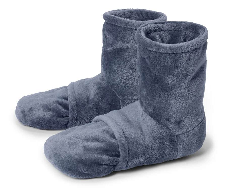 Gros plan de deux chaussons montants bleus en tissu sur fond blanc.