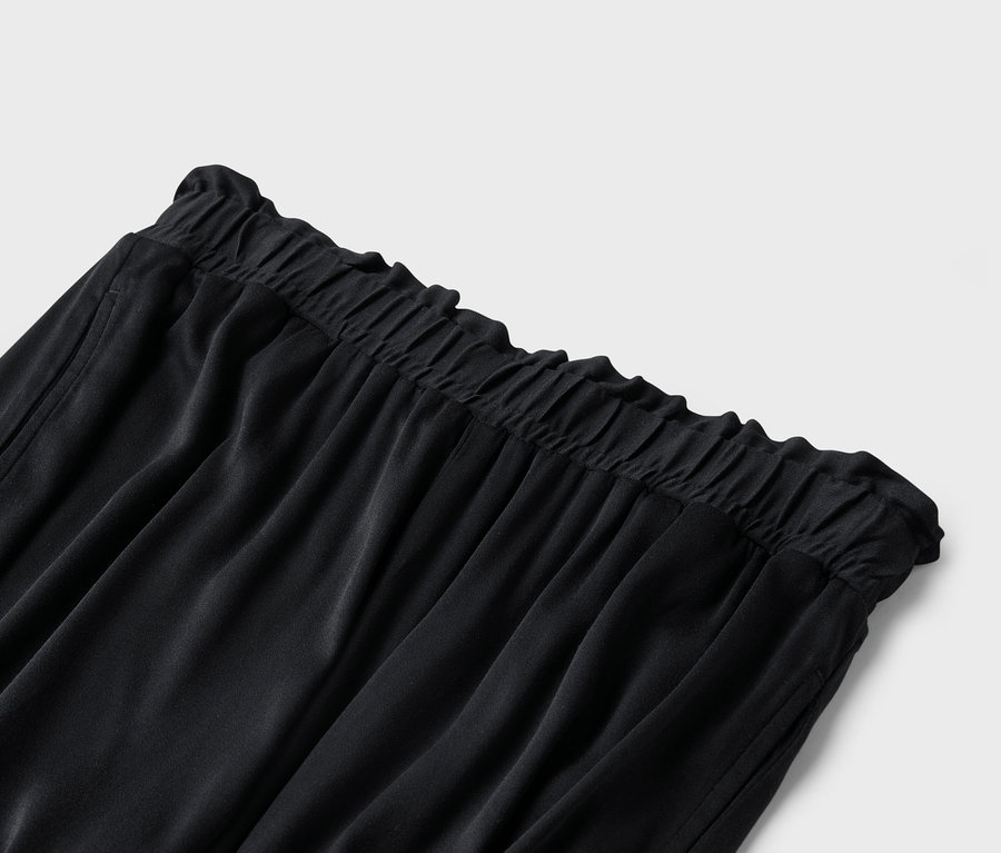 Gros plan sur un pantalon noir avec une taille élastique.