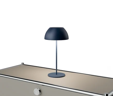 Une lampe bleue est posée sur une table beige avec des accents argentés.