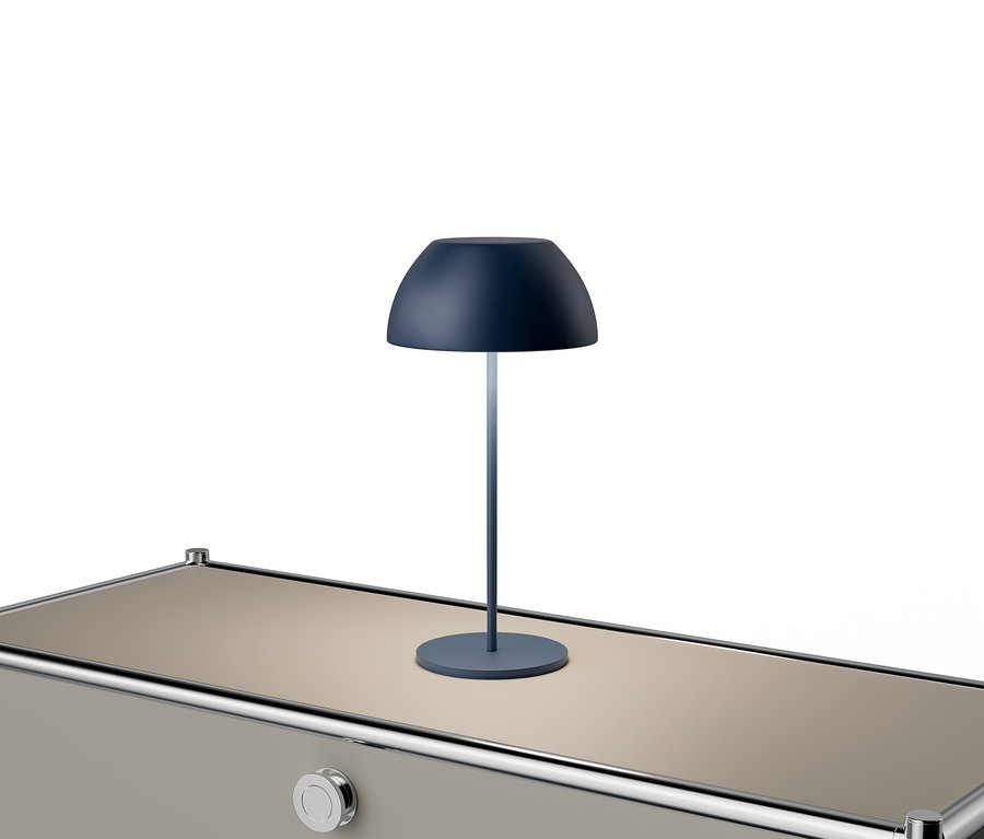 Une lampe bleue est posée sur une table beige avec des accents argentés.