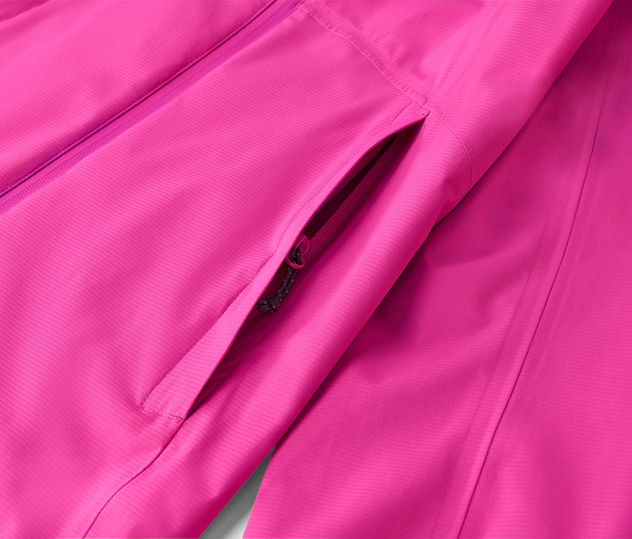 Gros plan d'une veste rose avec une poche zippée.