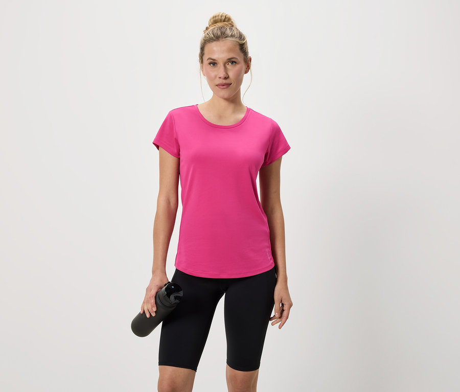 Femme en t-shirt rose et cycliste noir tenant une bouteille d'eau noire.
