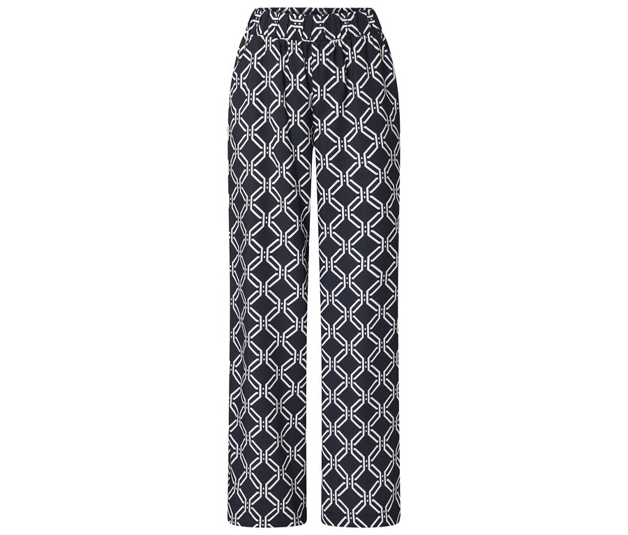 Un pantalon avec un motif géométrique en noir et blanc est posé sur un fond blanc.