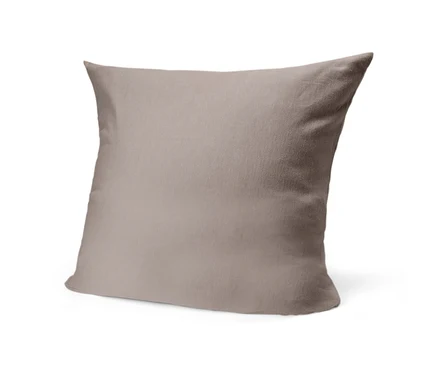 Un coussin carré de couleur marron clair, légèrement incliné vers la gauche, avec un tissu doux.