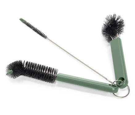 Trois brosses de nettoyage avec des manches verts et des poils noirs sont posées sur un fond blanc. Une brosse est longue et fine, tandis que les deux autres ont des manches plus courts et des têtes de brosse rondes, toutes reliées par un anneau métallique.