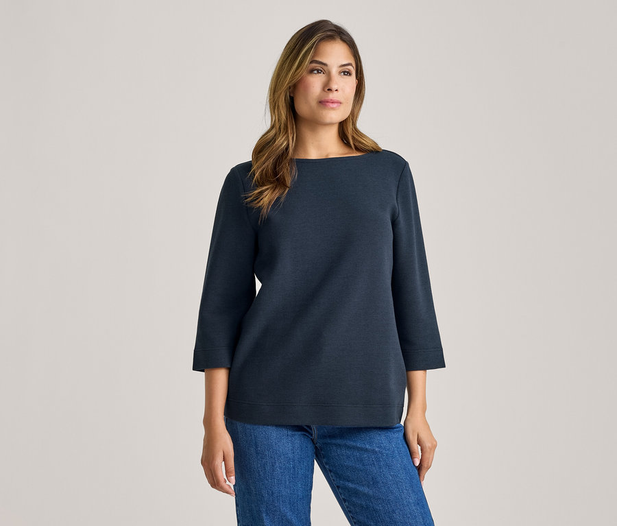 Femme portant un haut bleu foncé à manches 3/4 et un jean bleu.