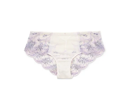 Une paire de culottes blanches pour femmes avec des broderies florales bleues reposent sur un fond blanc.