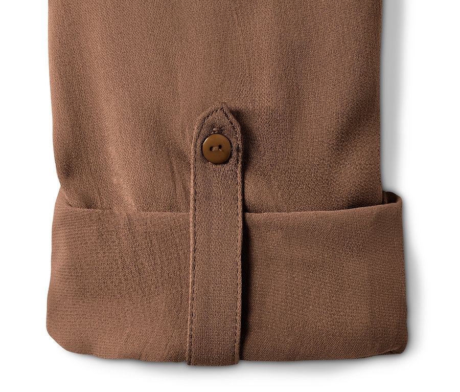 Détail d'une robe-chemisier marron avec un bouton.