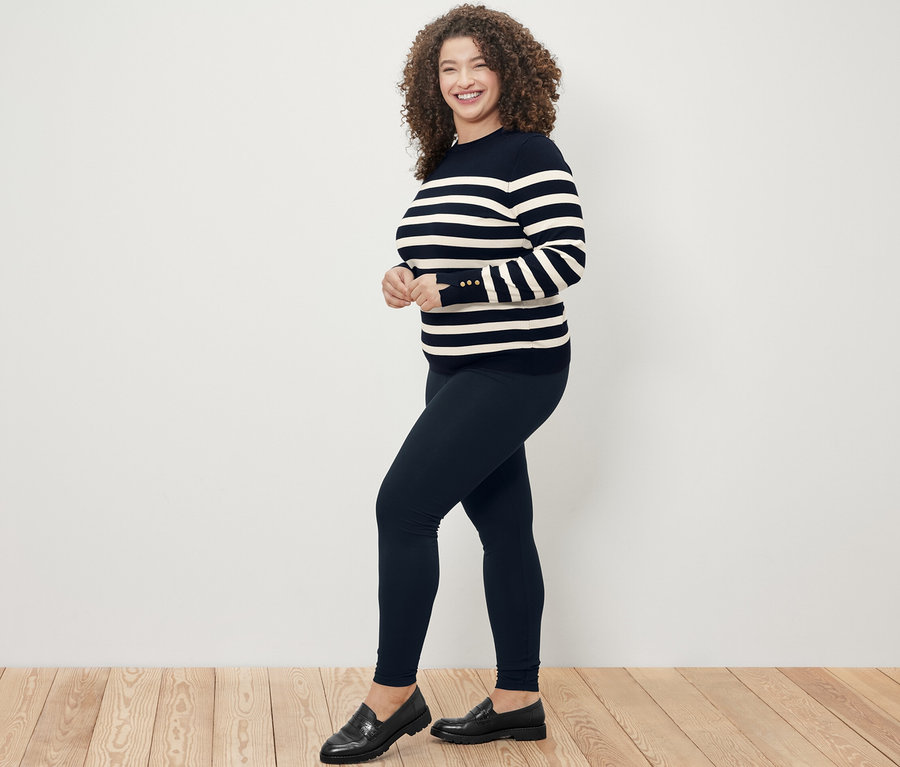 Femme posant en pull en maille fine rayé bleu foncé et legging Heavy noir.