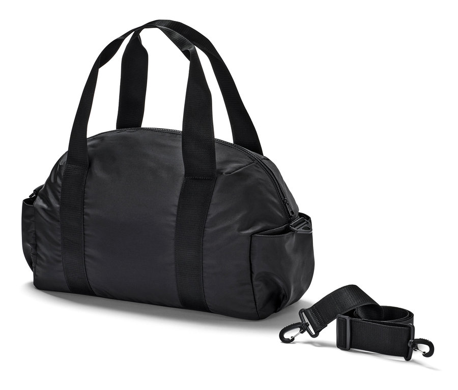 Un sac de sport noir est posé à côté d'une bandoulière amovible.