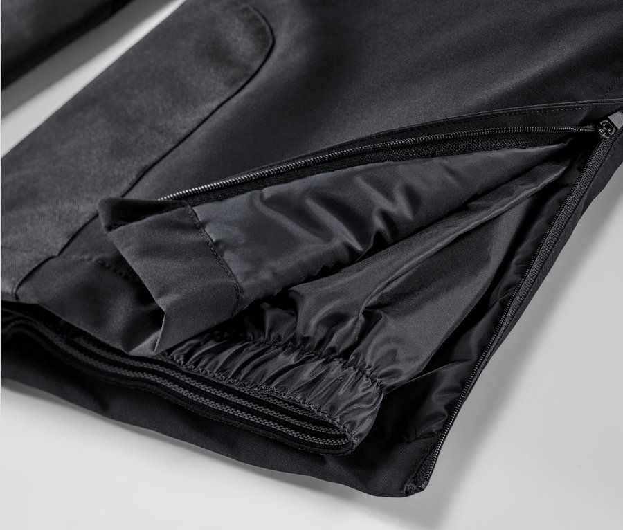 Détail d'un pantalon de ski noir avec fermeture éclair.