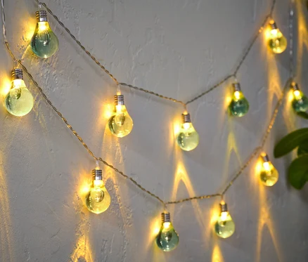 Guirlande lumineuse « ampoules » accrochée au mur, allumée.