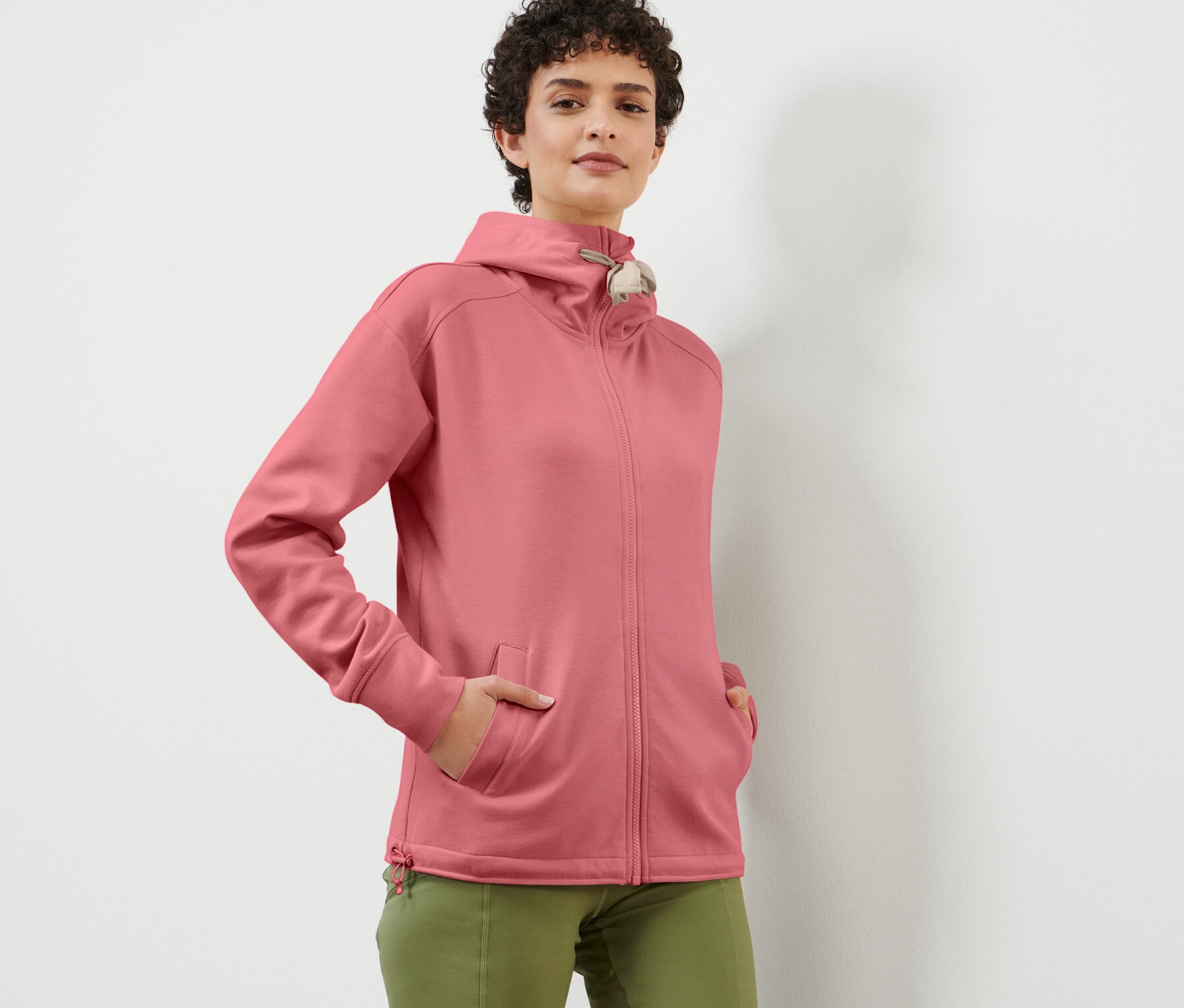 Femme posant dans une veste à capuche rose.