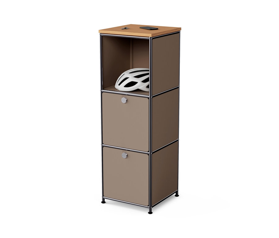 Commode étroite en métal « CN3 » avec plateau en bois et 2 abattants, taupe. Un casque blanc est visible dans le compartiment supérieur ouvert.