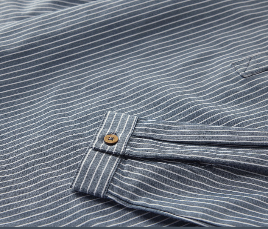 Gros plan sur une chemise pour enfant rayée avec un bouton.