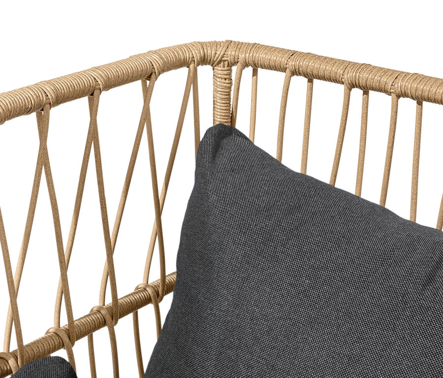 Gros plan d'un canapé lounge avec repose-pieds, doté d'un cadre en rotin marron et d'un coussin gris.