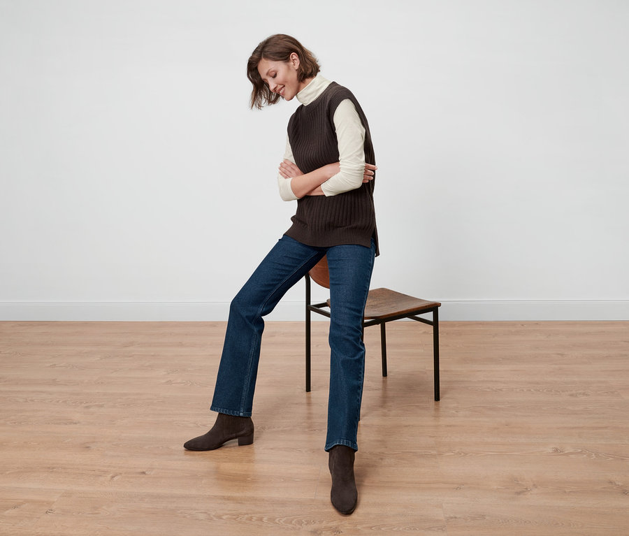 Femme assise sur une chaise portant un t-shirt col roulé à manches longues, crème.