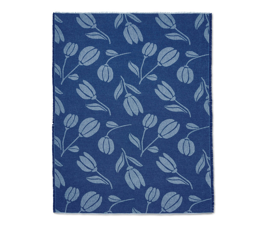 Couverture d’intérieur bleue avec franges et motif de tulipes.