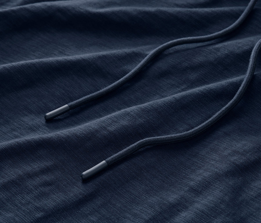 Gros plan sur le tissu d'un sweat en jersey bleu marine avec cordon de serrage.