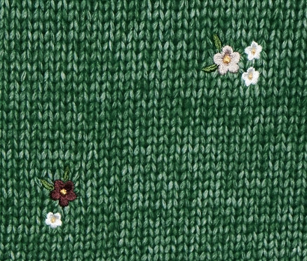 Pull en grosse maille vert avec col en V et détails floraux.