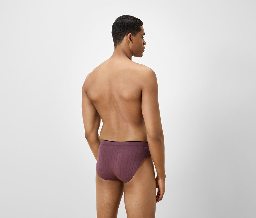 Homme vu de dos portant un slip bordeaux.