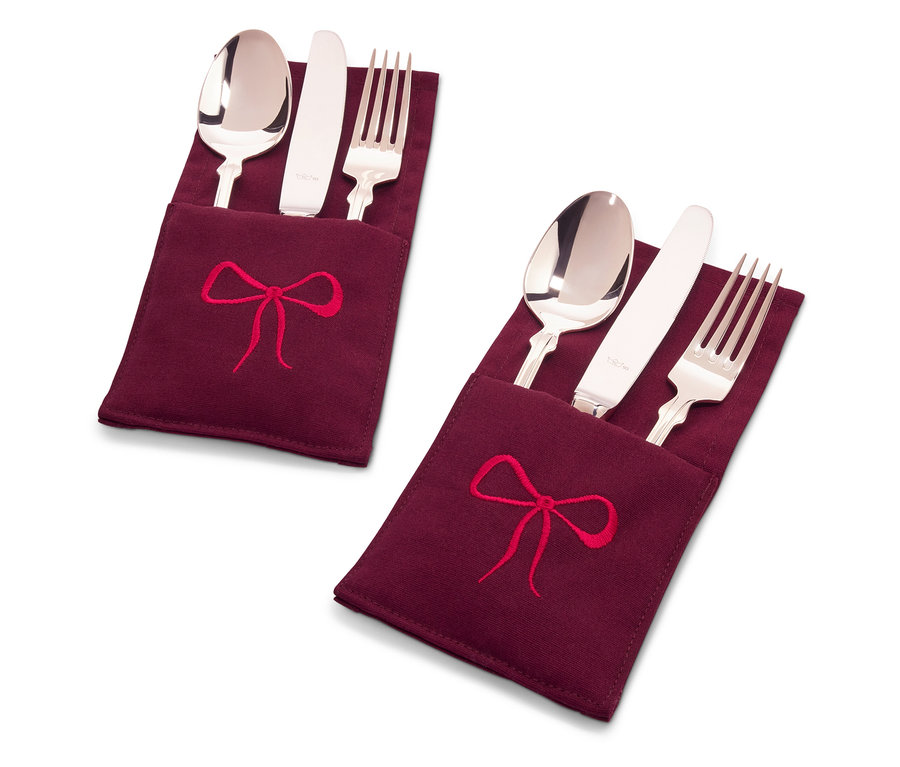 Deux ensembles de couverts dans des étuis en tissu bordeaux avec une broderie de nœud rouge.