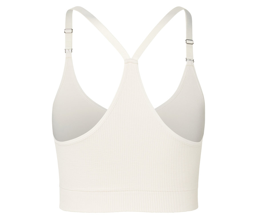 Gros plan d'une brassière de sport couleur crème avec une texture côtelée et de fines bretelles.