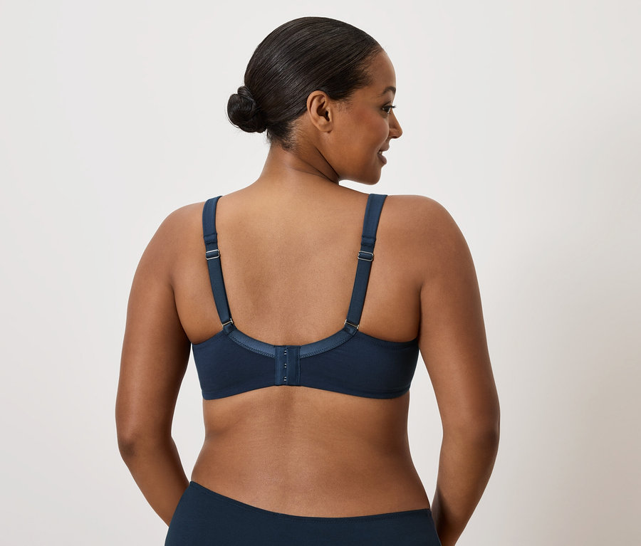 Femme aux cheveux foncés portant un soutien-gorge bleu foncé.