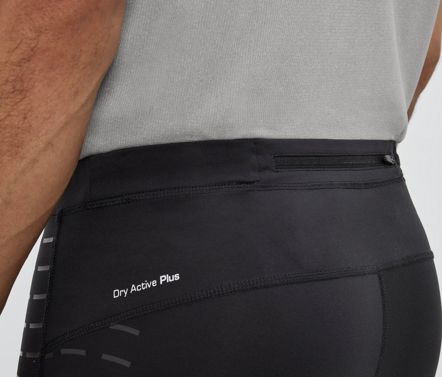 Un homme porte des leggings noirs avec l'inscription Dry Active Plus et une poche zippée à la taille.