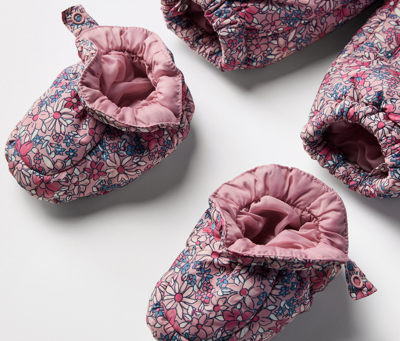 Gros plan de chaussons pour bébé de la combinaison d’hiver pour bébé avec motif floral.
