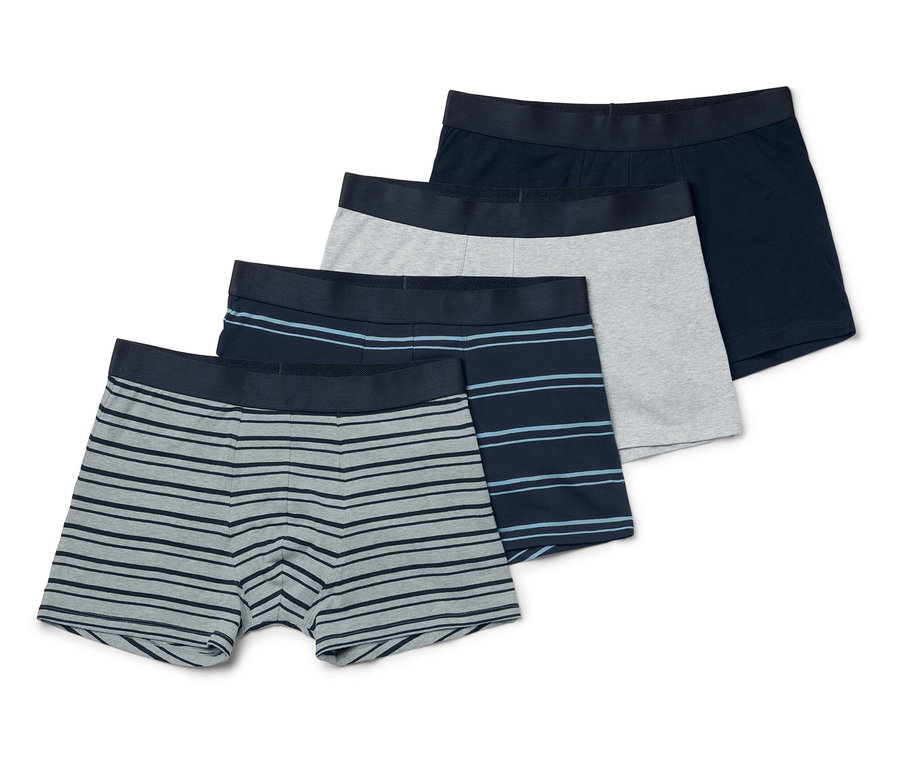 Quatre boxers pour hommes sont posés les uns sur les autres. Un est bleu foncé, un gris et deux rayés.