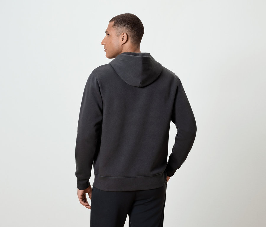 Homme vu de dos portant un sweat à capuche gris foncé.