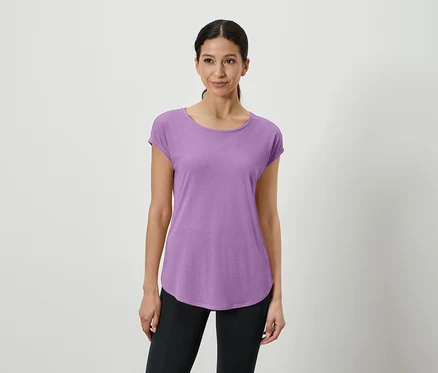 Une femme porte un t-shirt violet et un legging noir.
