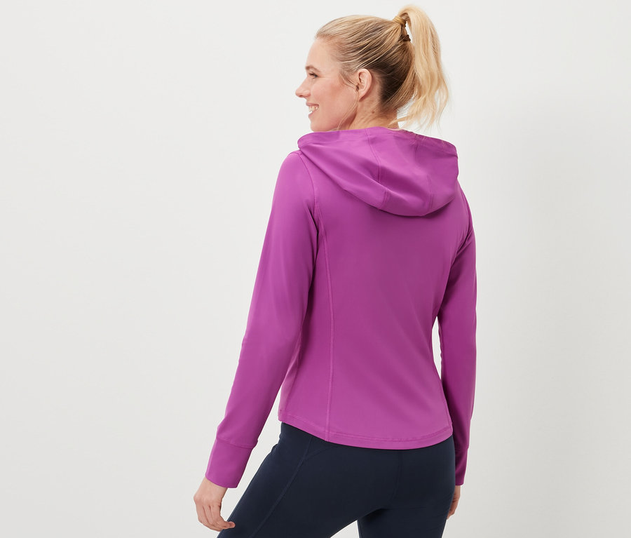 Femme portant une veste de sport et des leggings bleu marine.