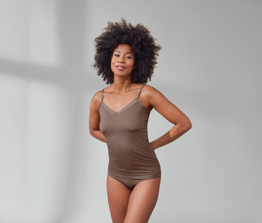 Afro-américaine posant en nuisette nougat et 5 culottes Magic Cut beiges.