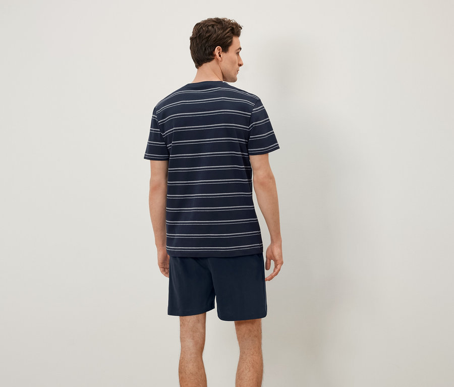 Un homme vu de dos porte un t-shirt rayé et un short.