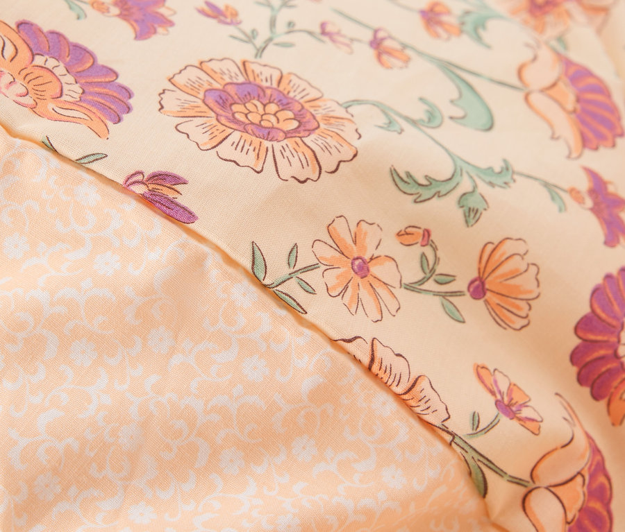 Gros plan d'un oreiller à motif floral.