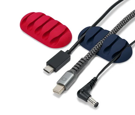 Supports de câbles en silicone rouge et bleu avec divers câbles sur fond blanc.