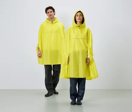 Un homme et une femme se tiennent côte à côte, portant des ponchos de pluie jaunes à capuche et des bandes réfléchissantes sur fond blanc.